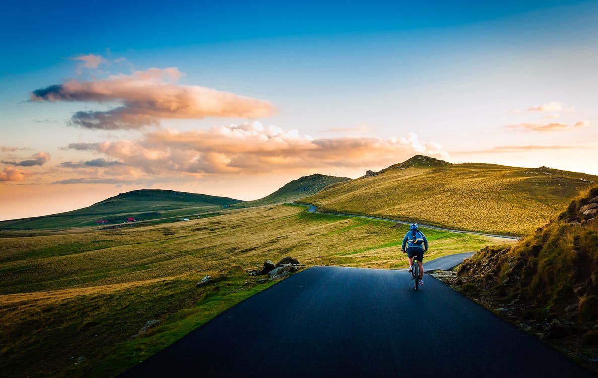 Rear view of man on mountain road against the skies