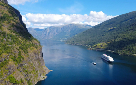 Fjord cruise boat travelling through a narrow Norwegian fjord
